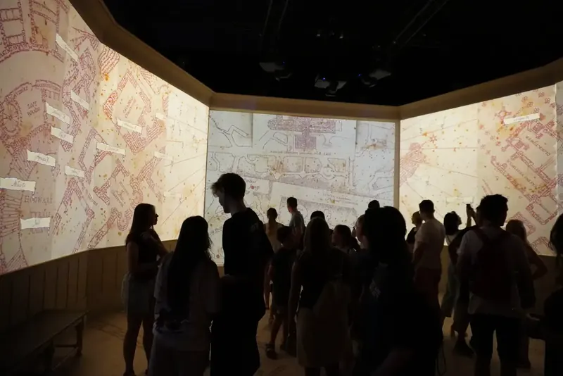 Immersiver Raum der Ausstellung mit Projektionen der Karte des Rumtreibers an den Wänden